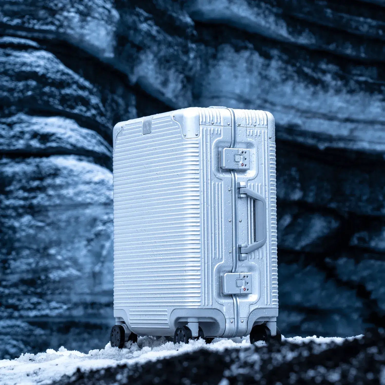 Sleek silver suitcase on a snowy landscape, highlighting durability and style for travelers.