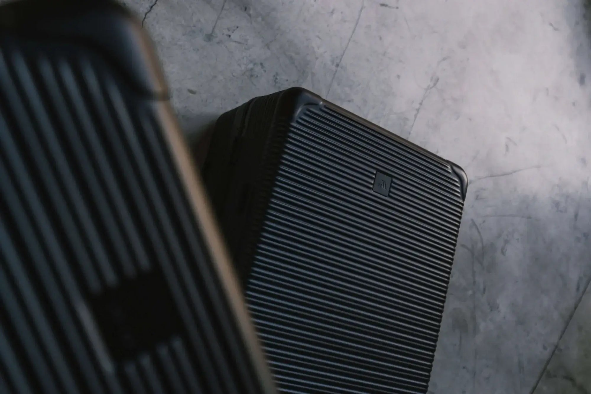 Stylish black Signature Advanced Cases on a textured gray surface, showcasing modern design and durability.